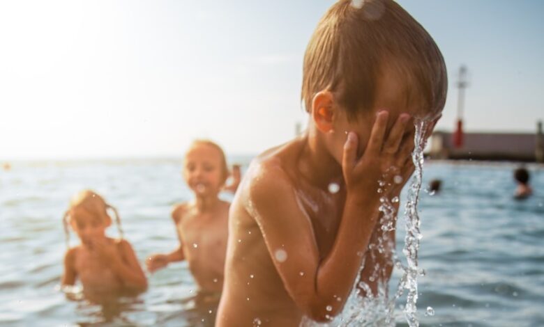 toddler pouring a water on his face